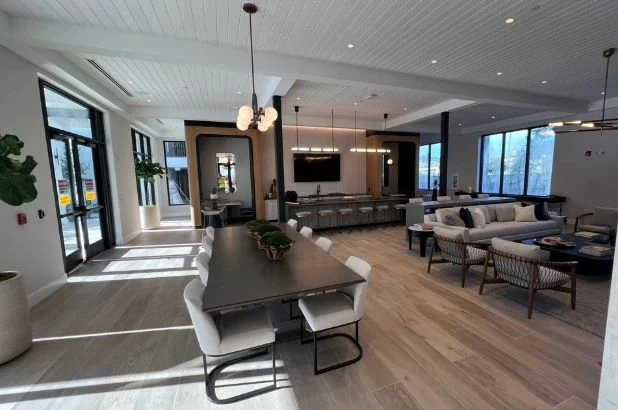 Amenity lounge with dining table, sofas and clean wood floors