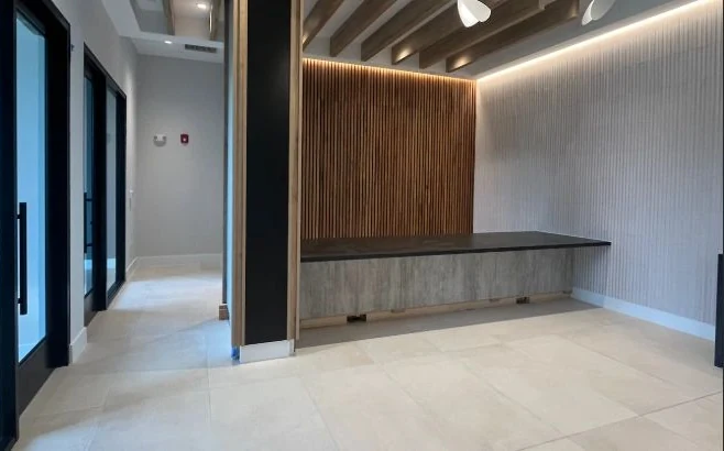 Clean reception desk with a wood slat wall and tile floor