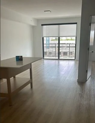 Empty apartment living room with clean floors and balcony doors