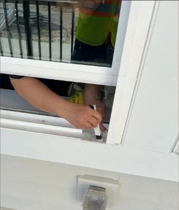 Crew member wiping a window track by hand